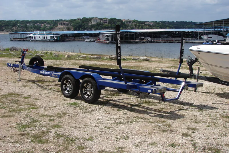 Slide: The Image of Trailer for 2017 Malibu Wakesetter 24 MXZ by a lakeside marina. - 50
