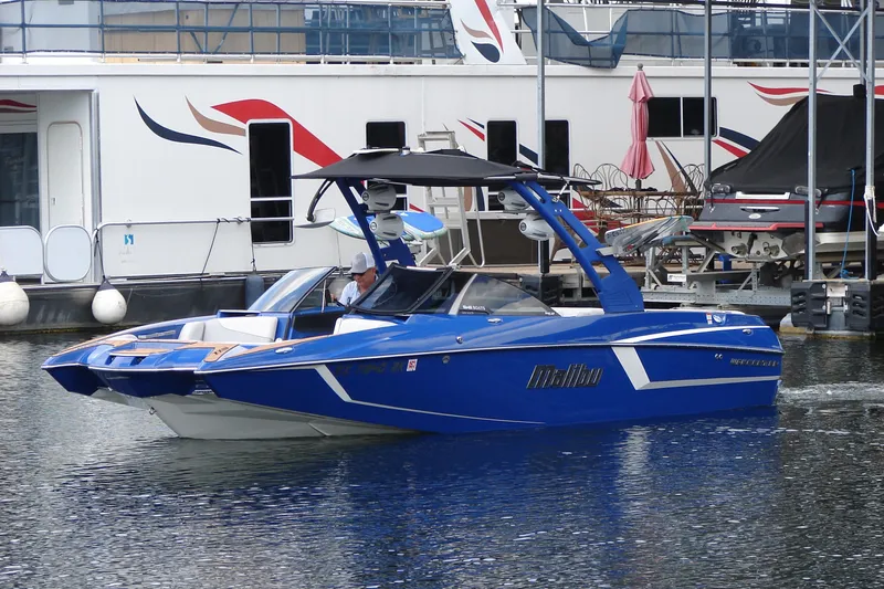 Slide: The Image of 2017 Malibu Wakesetter 24 MXZ boat in marina, blue exterior, sleek design. - 7