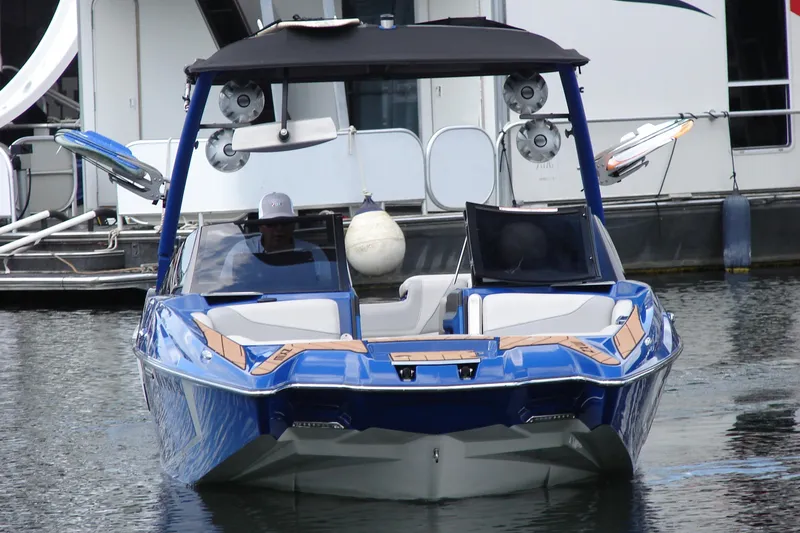 Slide: The Image of 2017 Malibu Wakesetter 24 MXZ boat docked, featuring sleek blue design and modern wakeboard tower. - 8