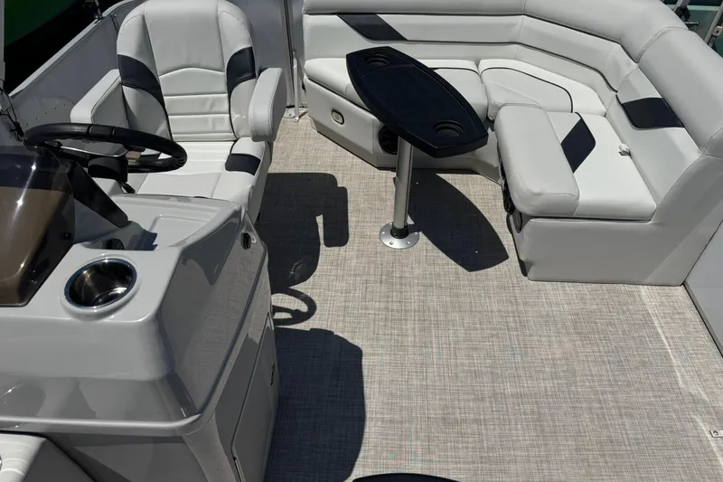 Slide: The Image of 2022 SunCatcher Select 16C boat interior with plush seating and steering console. - 13