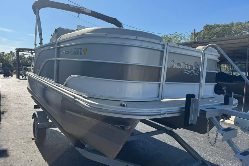Slide: The Image of 2022 SunCatcher Select 16C pontoon boat on trailer, parked outdoors. - 3