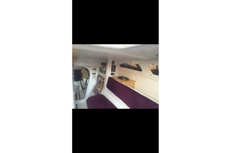 Slide: The Image of Interior of 1991 Corsair F 27 sailboat with purple seating and navigation equipment. - 3