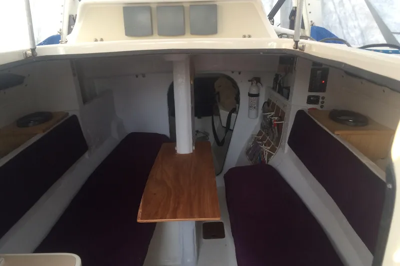 Slide: The Image of Interior of a 1991 Corsair F 27 sailboat with seating and a wooden table. - 6