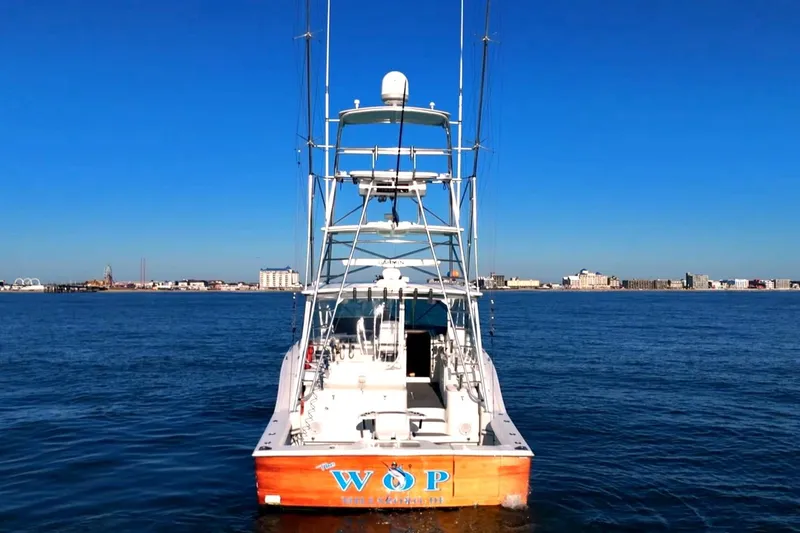 Slide: The Image of 2003 Cabo 40 Express boat on calm water with city skyline in background. - 10