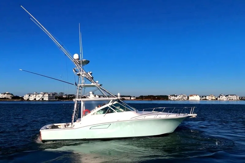 Slide: The Image of 2003 Cabo 40 Express boat cruising on a calm blue sea under clear skies. - 12