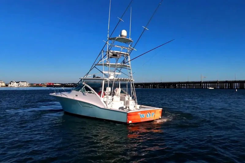 Slide: The Image of 2003 Cabo 40 Express boat cruising on open water under clear blue sky. - 14