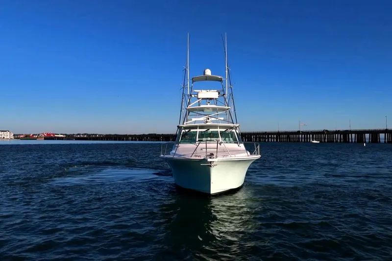 Slide: The Image of 2003 Cabo 40 Express boat on open water with clear blue sky. - 15