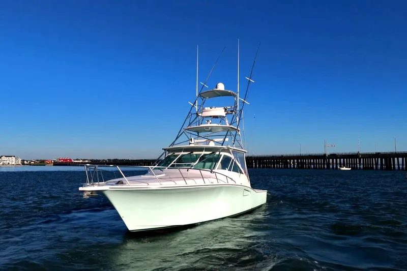 Slide: The Image of 2003 Cabo 40 Express yacht cruising on open water under clear blue sky. - 17