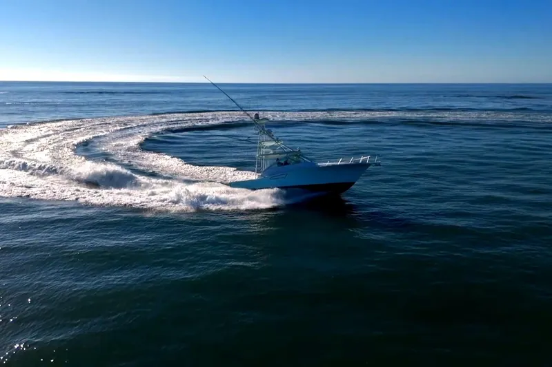 Slide: The Image of 2003 Cabo 40 Express boat making a sharp turn on open water. - 19