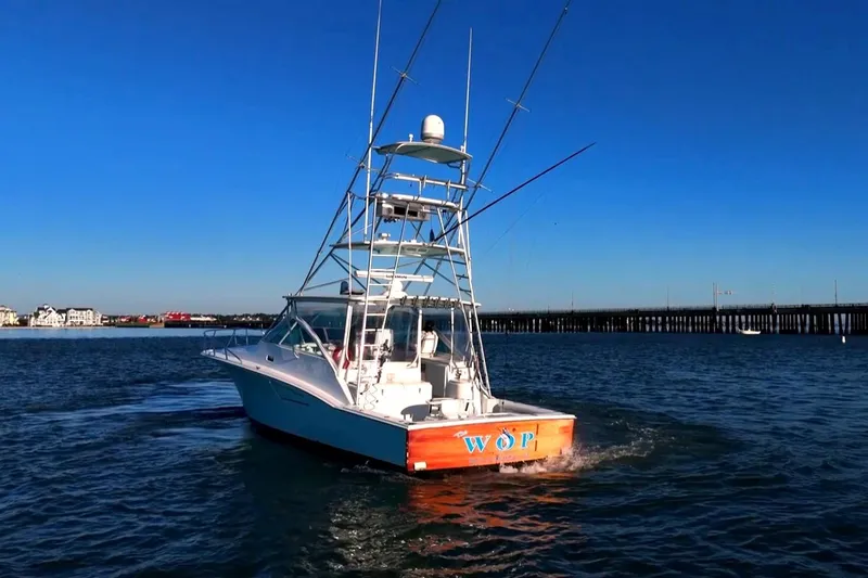 Slide: The Image of 2003 Cabo 40 Express boat cruising on open water under clear blue sky. - 20