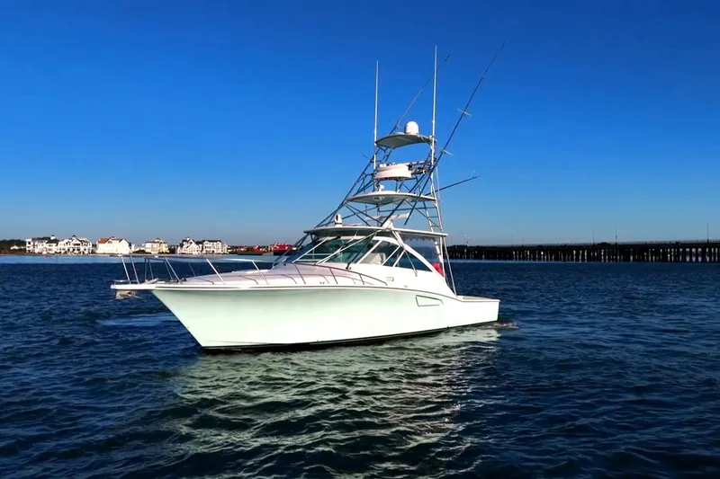 Slide: The Image of 2003 Cabo 40 Express yacht on calm water under clear blue sky. - 4