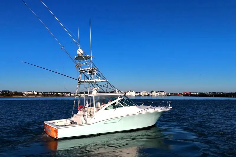 Slide: The Image of 2003 Cabo 40 Express boat cruising on calm waters under clear blue sky. - 5