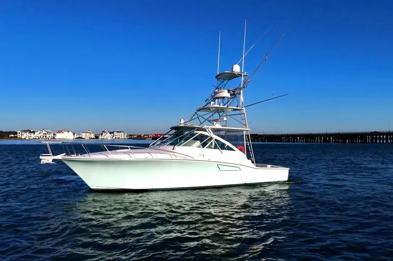Slide: The Image of 2003 Cabo 40 Express yacht on calm water under clear blue sky. - 9