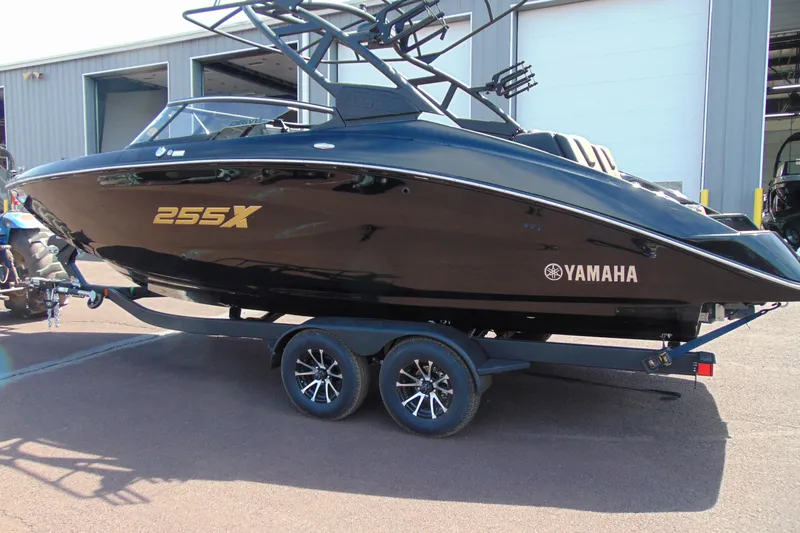 Slide: The Image of 2026 Yamaha Boats 255XD in black, parked on a trailer outside a building. - 3