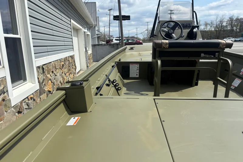 Slide: The Image of 2026 Crestliner 1870 Retriever FCC boat, olive green, parked near a stone building. - 4