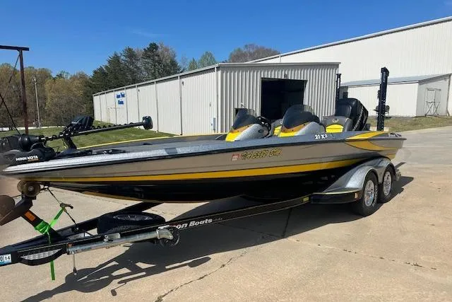 The Image of 2008 Triton 21X2 DC boat on trailer, parked outside a warehouse. - 0