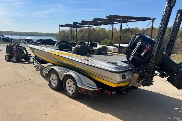 Slide: The Image of 2008 Triton 21X2 DC boat with Mercury engine on trailer, parked near a lake. - 2