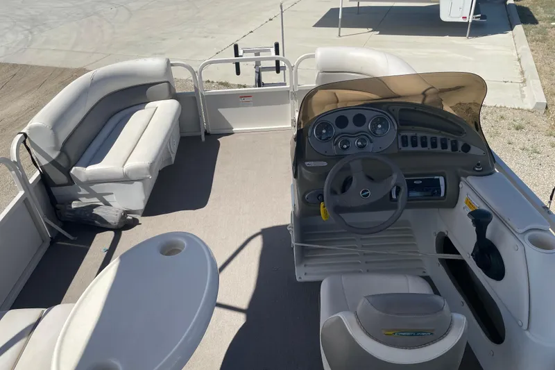 Slide: The Image of 2005 Crestliner Sport Classic 1685 pontoon boat interior with steering console and seating. - 2