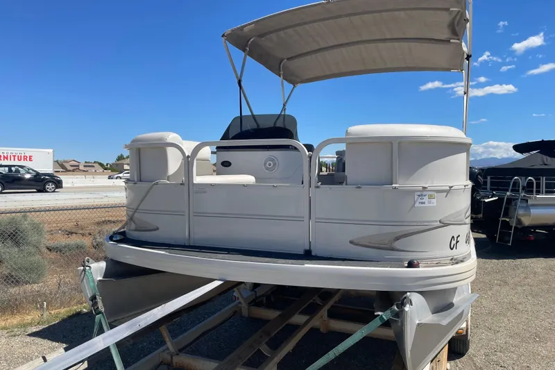 Slide: The Image of 2005 Crestliner Sport Classic 1685 pontoon boat on trailer under clear blue sky. - 4
