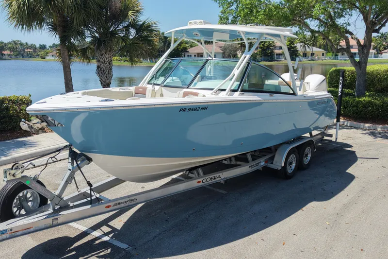 The Image of 2021 Cobia 280 Dual Console boat on trailer by a lake. - 0