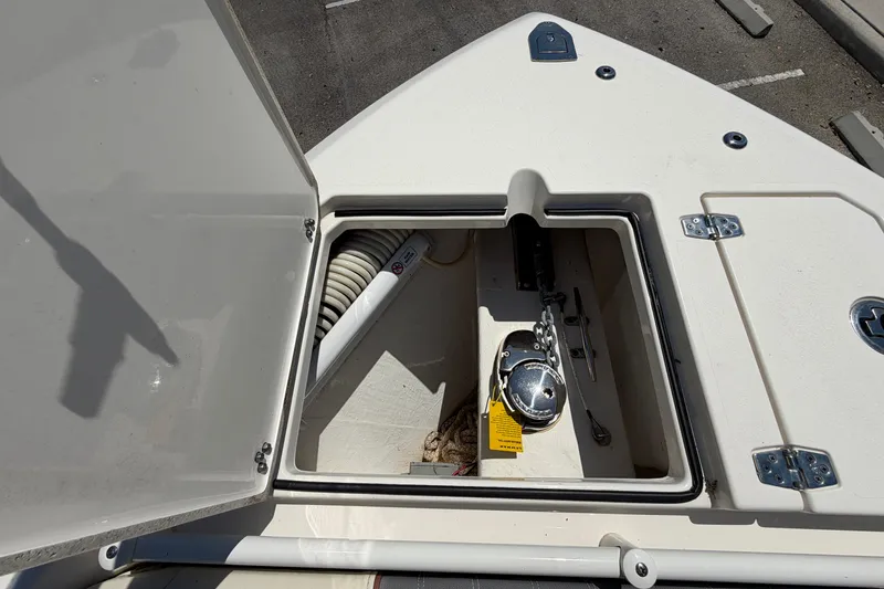 Slide: The Image of Open anchor compartment on 2021 Cobia 280 Dual Console boat, showing anchor and chain. - 10
