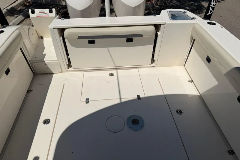 Slide: The Image of 2021 Cobia 280 Dual Console boat deck with storage compartments and seating. - 15