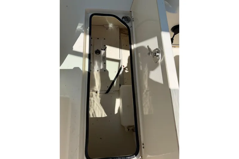 Slide: The Image of Open storage compartment on a 2021 Cobia 280 Dual Console boat. - 18