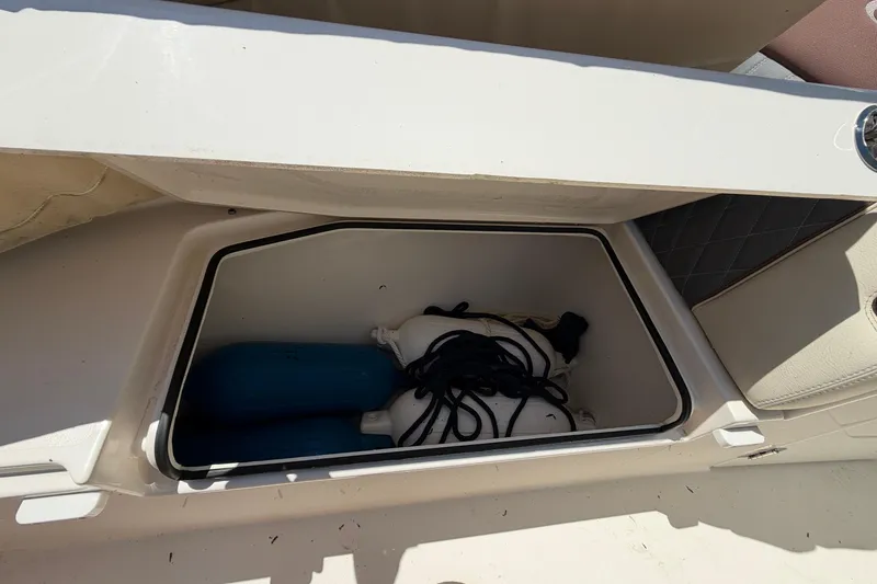 Slide: The Image of Storage compartment on a 2021 Cobia 280 Dual Console boat with fenders and ropes. - 19