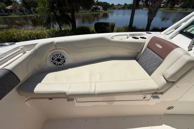 Slide: The Image of 2021 Cobia 280 Dual Console boat interior with cushioned seating and speaker. - 21