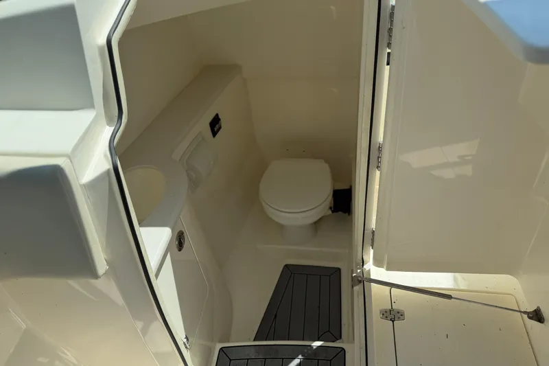 Slide: The Image of Interior view of 2021 Cobia 280 Dual Console boat bathroom with toilet and sink. - 22