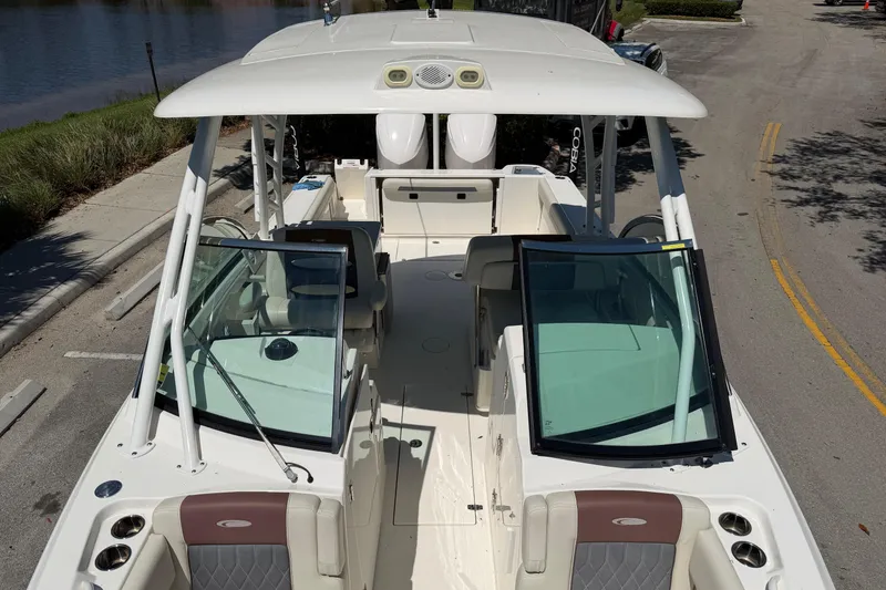 Slide: The Image of 2021 Cobia 280 Dual Console boat with open seating and windshield, parked near water. - 7