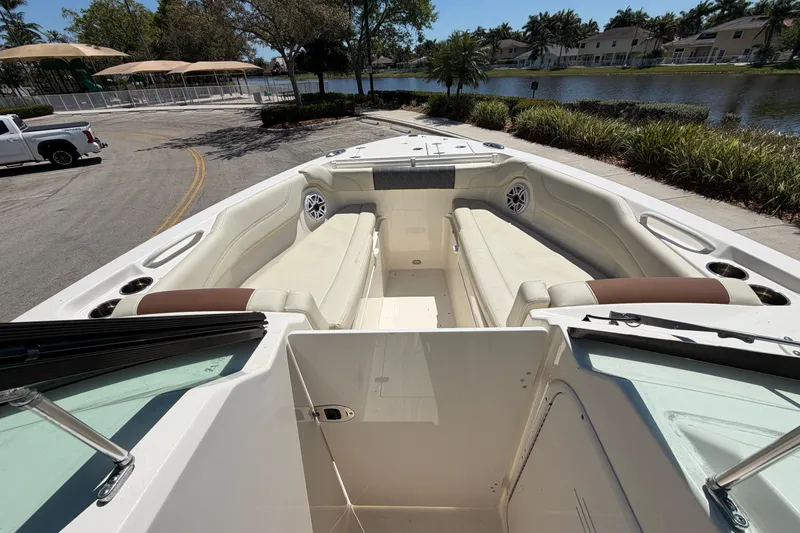 Slide: The Image of 2021 Cobia 280 Dual Console boat with spacious seating, parked near a scenic waterfront. - 9