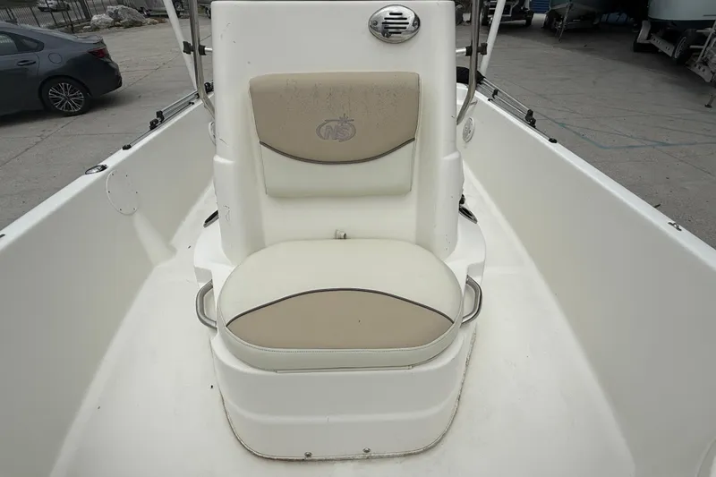 Slide: The Image of 2018 NauticStar 2140 Sport boat seat with beige cushions and logo. - 11