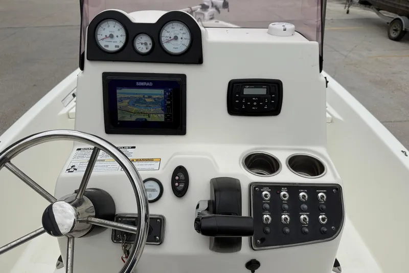Slide: The Image of 2018 NauticStar 2140 Sport boat dashboard with steering wheel, gauges, and navigation system. - 14