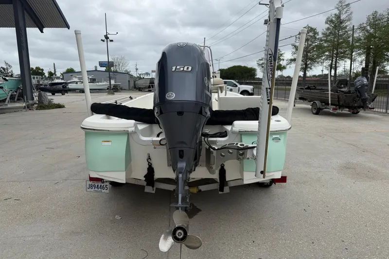 Slide: The Image of 2018 NauticStar 2140 Sport boat with 150 HP outboard motor, parked outdoors. - 5