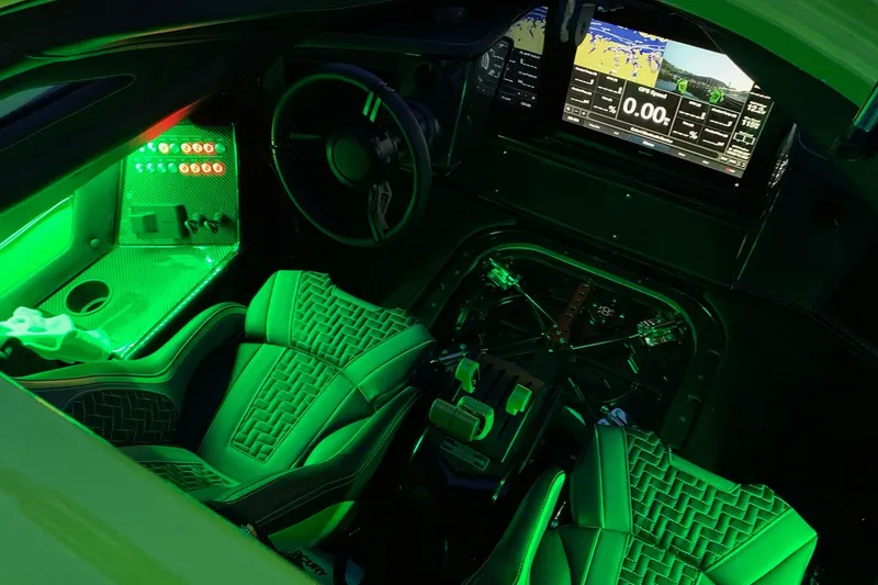 Slide: The Image of Green MTI 390XR boat with open hatches, docked under a canopy, 2023 model. - 10