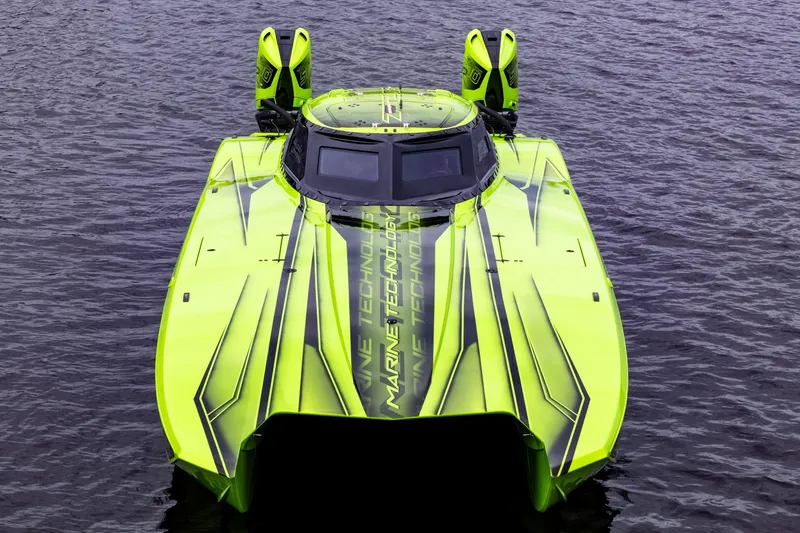 Slide: The Image of Bright green 2023 MTI 390XR powerboat on water, showcasing sleek design and twin engines. - 14