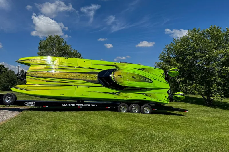 Slide: The Image of Bright green MTI 390XR speedboat on trailer, parked on grass under blue sky. - 15