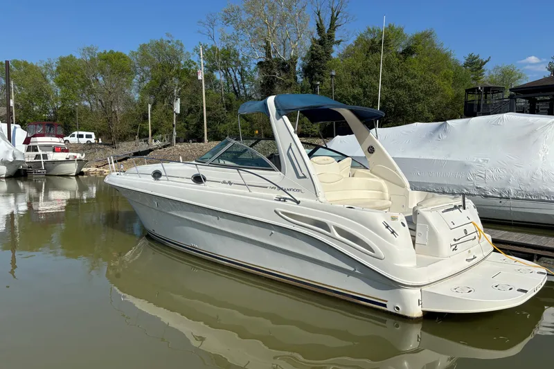 The Image of 2001 Sea Ray 340 Sundancer boat docked in a marina, surrounded by trees. - 0