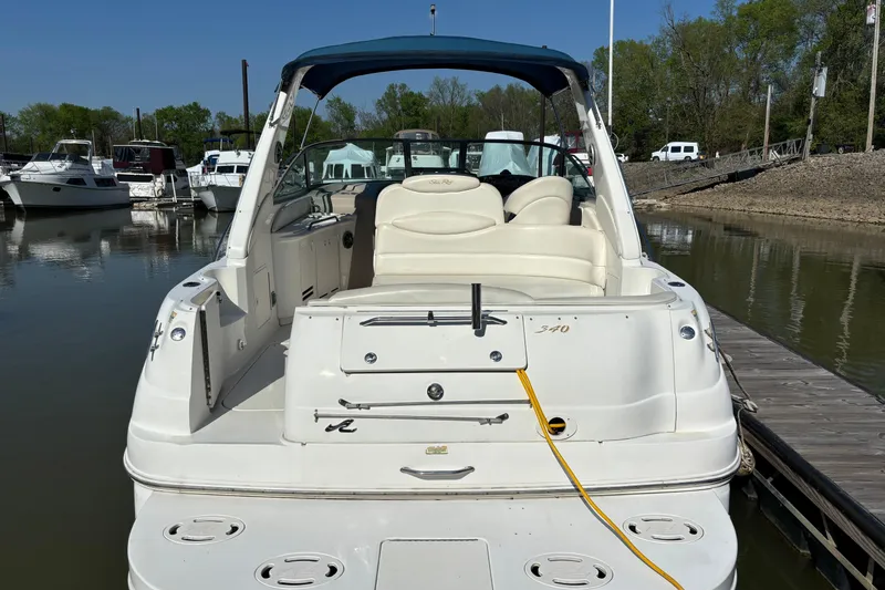 Slide: The Image of 2001 Sea Ray 340 Sundancer docked at marina, rear view with seating and canopy. - 2