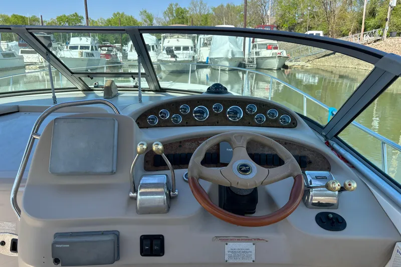 Slide: The Image of Helm of 2001 Sea Ray 340 Sundancer with steering wheel and control panel, docked at marina. - 5