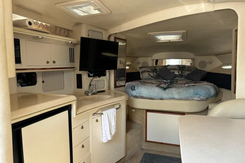 Slide: The Image of Interior of 2001 Sea Ray 340 Sundancer with cozy bed, kitchenette, and TV. - 8