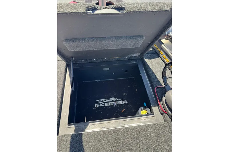 Slide: The Image of Open storage compartment in a 2005 Skeeter ZX225 boat, showing interior details. - 12