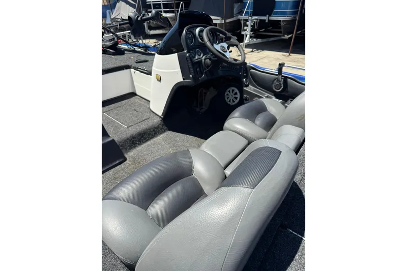 Slide: The Image of 2005 Skeeter ZX225 boat interior with steering wheel and gray seating. - 9