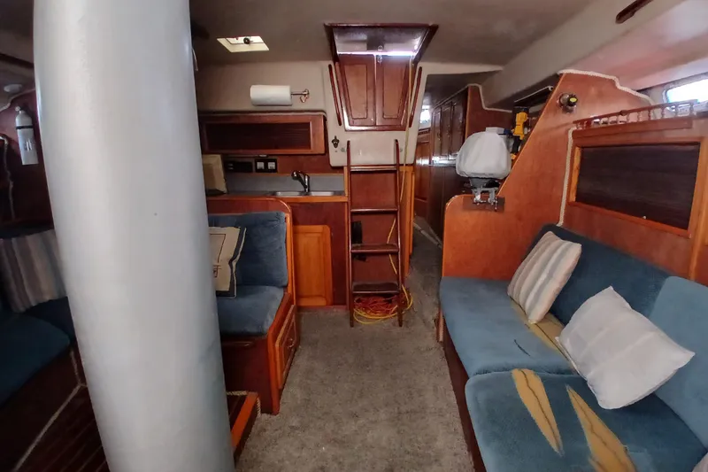 Slide: The Image of Interior of a 1982 Morgan 416 sailboat with cozy seating and wooden cabinetry. - 10