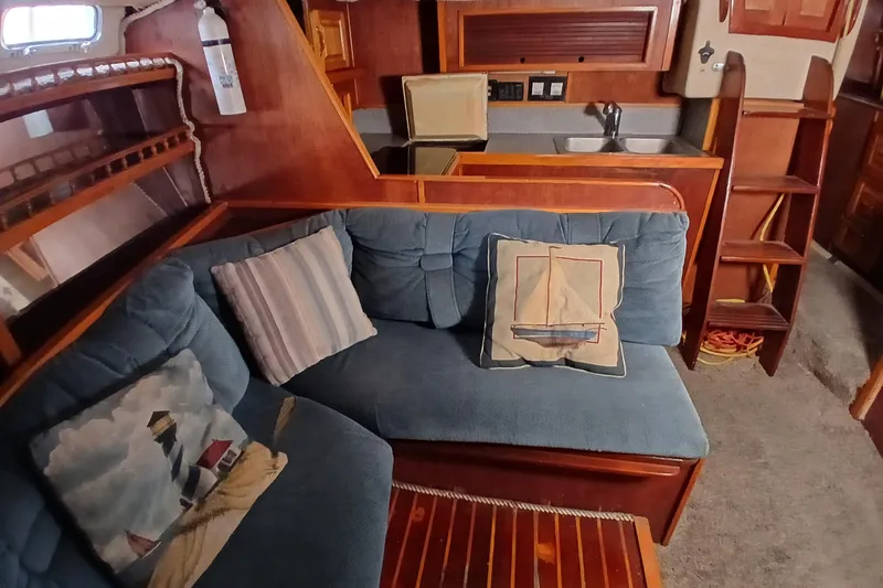 Slide: The Image of Interior of 1982 Morgan 416 yacht with cozy seating and nautical-themed pillows. - 11