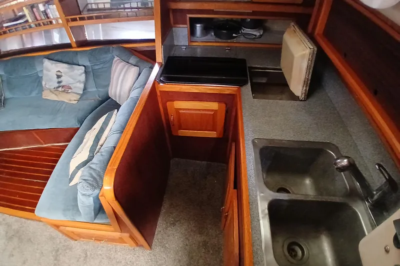 Slide: The Image of Interior of a 1982 Morgan 416 yacht featuring a cozy seating area and compact kitchen. - 14