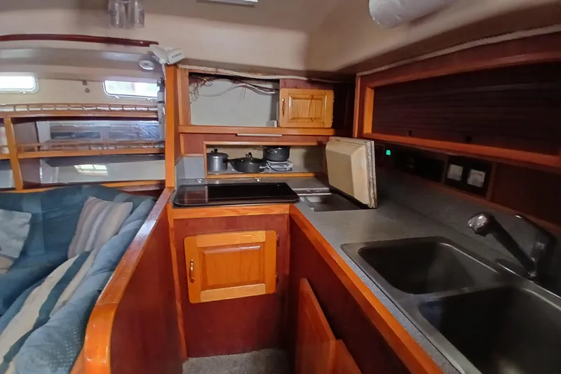 Slide: The Image of Interior of 1982 Morgan 416 yacht featuring a compact kitchen with wooden cabinetry. - 17