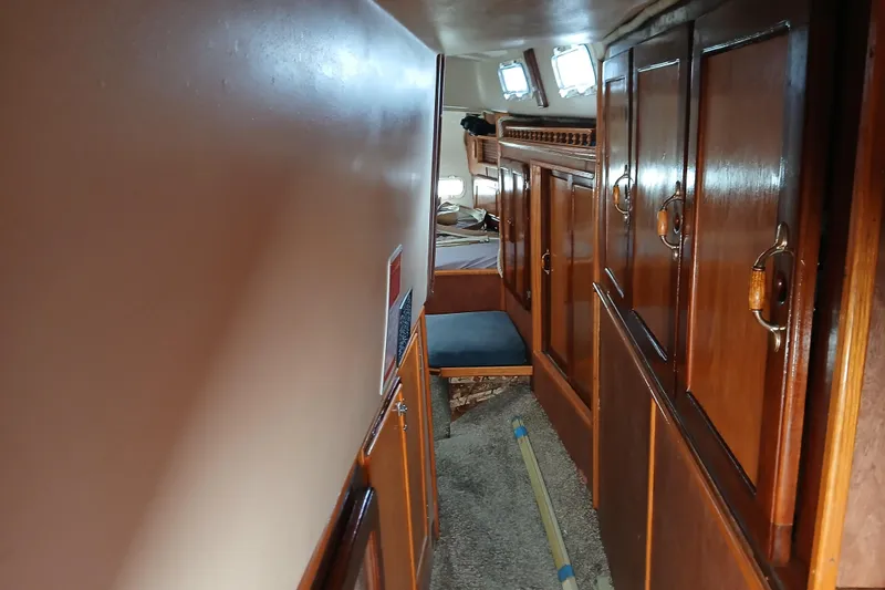 Slide: The Image of Interior of 1982 Morgan 416 sailboat with wooden cabinets and cozy sleeping area. - 19