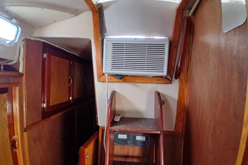 Slide: The Image of Interior of a 1982 Morgan 416 sailboat with wooden cabinetry and air conditioning unit. - 21